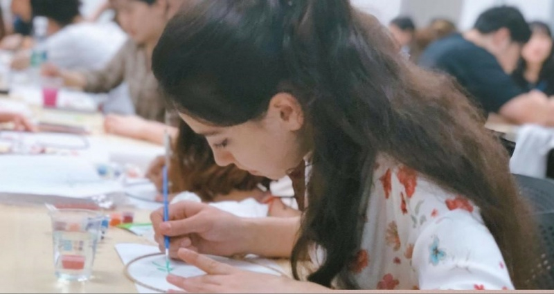 职工正专心绘制团扇